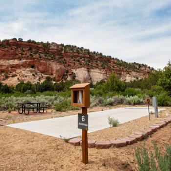 RV site with red rocks and blue sky in the background